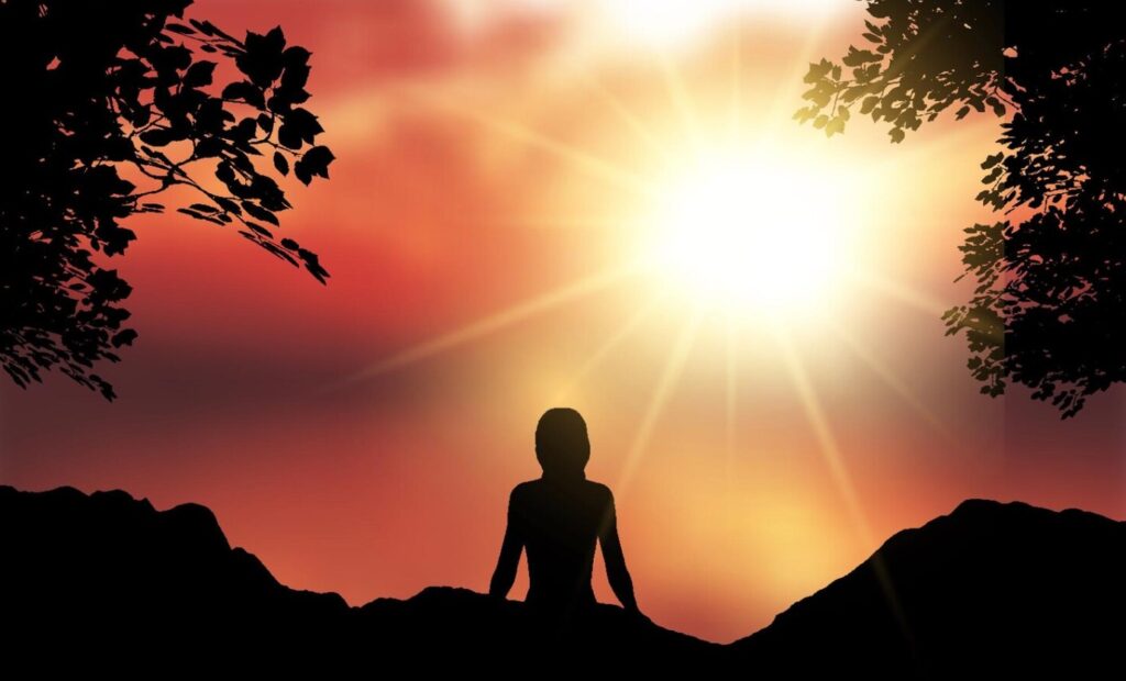 Silhouette d’une personne méditant face à un lever de soleil éclatant, entourée de feuillage et de montagnes, évoquant la sérénité, la reconnexion à soi et le bien-être naturel.